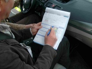 l'inspecteur note sur un papier les observations lors de la conduire